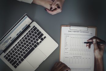 Aerial view of doctor writing patient daily report checklist